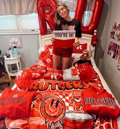 a girl is holding up a sign in her bed