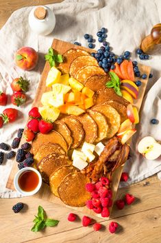 pancakes with fruit and syrup on a cutting board