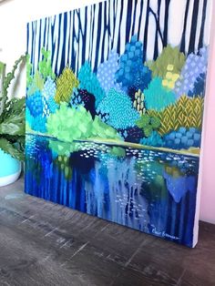 a painting on the wall next to a potted plant