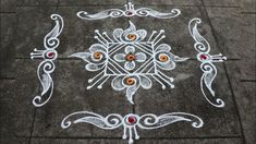 an intricately designed design on the ground with red and yellow stones in it's center