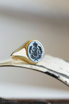 a close up of a gold ring with a seal on it