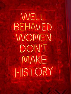 a red neon sign that says well behaved women don't make history