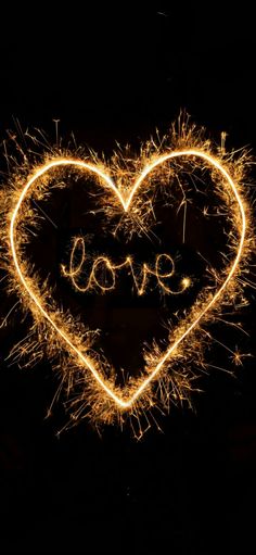 the word love spelled with sparklers in the shape of a heart