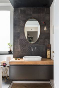 a bathroom with a sink, mirror and wooden counter top in front of a window