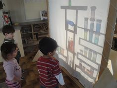 three children standing in front of a white board