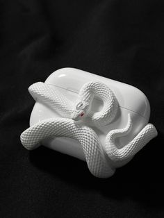 a white snake figurine sitting on top of a black surface