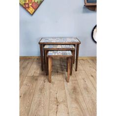 three wooden tables sitting on top of a hard wood floor next to a blue wall