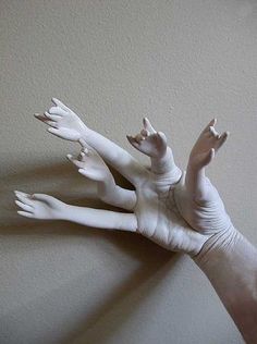 two white hands reaching up into the air