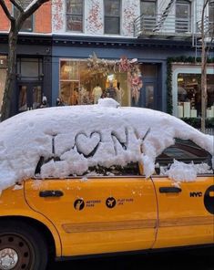 a taxi cab covered in snow with the word love written on it's windshield