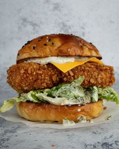 a fried chicken sandwich with lettuce and cheese