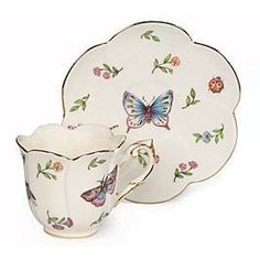 two tea cups and saucers with butterflies on them