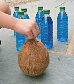 a person is picking up a coconut from a bunch of water bottles on the ground