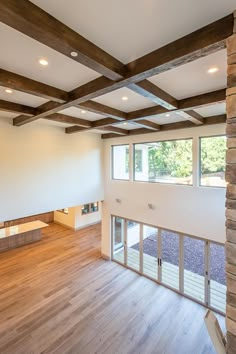 an empty living room with wood floors and exposed beams