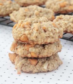 three oatmeal cookies stacked on top of each other in front of a cooling rack