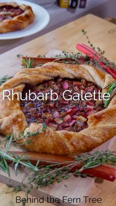 a close up of a pie on a cutting board with herbs and other food items