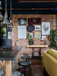 a brick wall with pictures on it and stools in front of the bar area