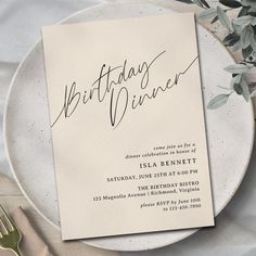 a white plate topped with a piece of paper next to a fork and knife on top of a table