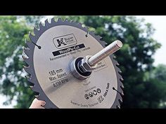 a person holding a circular saw with trees in the background