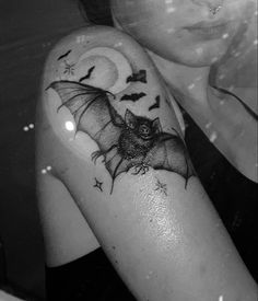 a woman with a bat and moon tattoo on her arm, in black and white