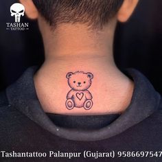 the back of a man's neck with a small teddy bear tattoo on it