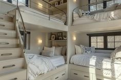 there are two bunk beds in the room with white linens and pillows on them