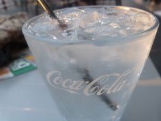 a glass filled with ice sitting on top of a table