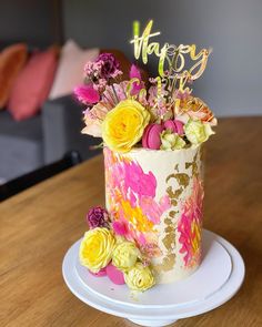 a birthday cake decorated with flowers on a table