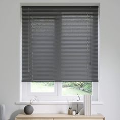 the blinds in this room are made from dark gray colored wood, and have been pulled down