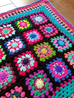 a crocheted granny granny blanket with multicolored flowers on the center and sides