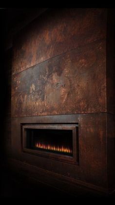 a fire place in the corner of a room with wood paneling on the wall