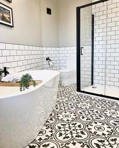 a bathroom with black and white tiles on the floor, walls and floors is shown