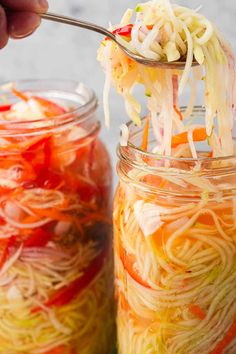 someone is spooning noodles out of a jar filled with it's contents to eat