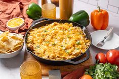 a casserole with cheese and vegetables on a cutting board next to other ingredients