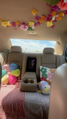 the back seat of a car with stuffed animals and balloons hanging from it's ceiling