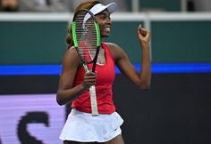 a woman holding a tennis racquet on top of a tennis court