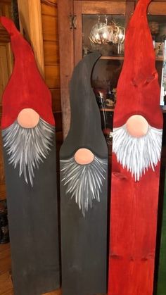 three wooden gnomes are standing next to each other