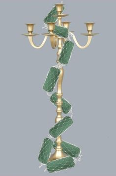 a gold candelabra with green leaves on it