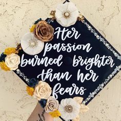 a graduation cap decorated with flowers and the words her passion burned brighter than her tears