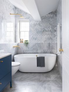 a white bath tub sitting next to a toilet in a bathroom