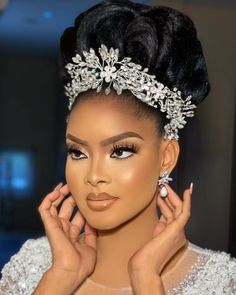 a woman wearing a tiara with pearls on her head and hands in front of her face