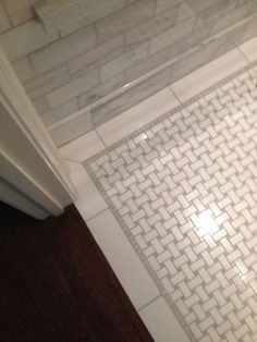 a bathroom with white tile and wood flooring