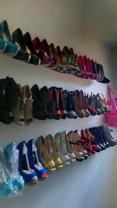 there are many pairs of shoes hanging on the wall next to each other in different colors