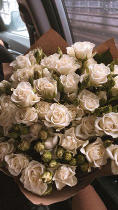 a bouquet of white roses sitting in the back seat of a car