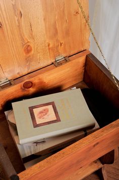 a book is sitting on top of a wooden bench with chains hanging from it's sides