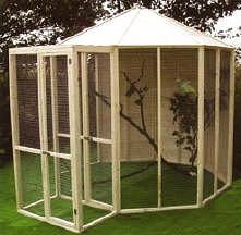 a large white gazebo sitting on top of a green grass covered field next to a tree