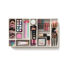 an assortment of cosmetics and makeup products in a drawer on a white background, top view