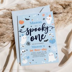 a blue halloween birthday party card with ghost, bats and pumpkins on the front