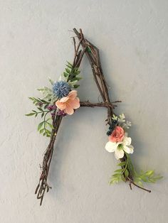 a floral letter made out of branches and twigs with flowers on the letters'a '