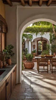 an archway leading to a dining area with potted plants