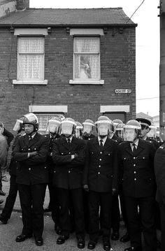 a group of police officers standing next to each other in front of a brick building